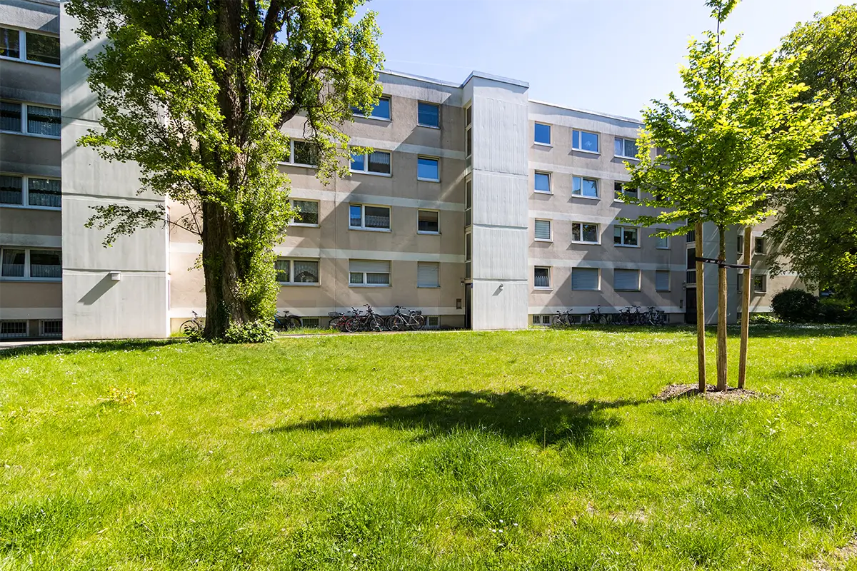 Mehrfamilienhaus in München-Forstenried mit Rasenfläche und alten Bäumen